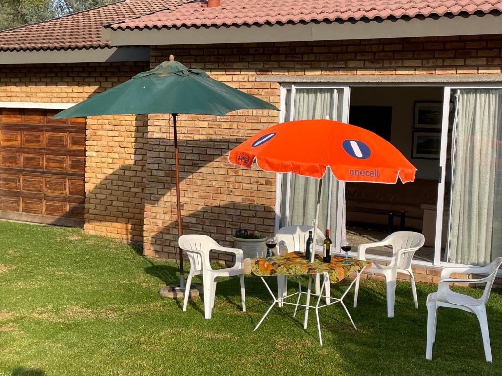 a table and two chairs and an umbrella at Golfview Lodge in De Deur