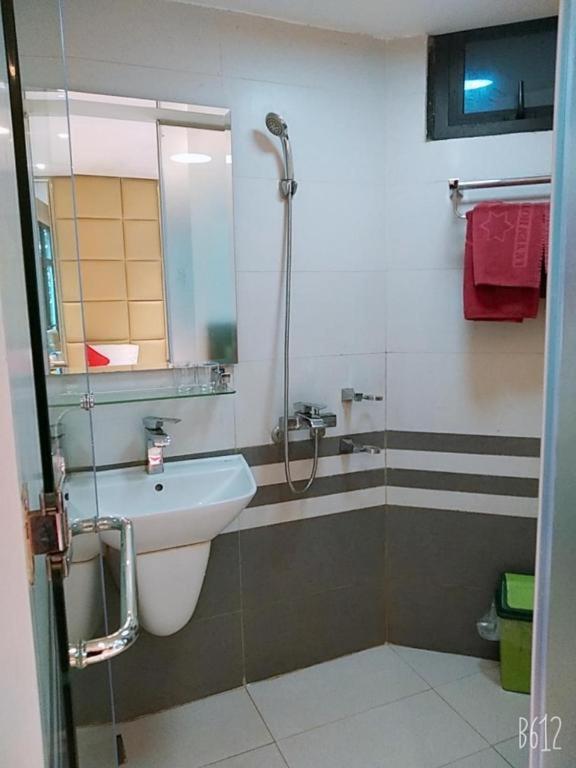 een badkamer met een wastafel en een douche met een spiegel bij Bích Ngọc - 4/94 Phố Ngọc Khánh - by BayHostel in Hanoi