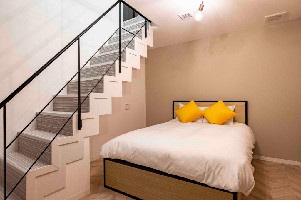 a bedroom with a bed and a staircase at HJ PLACE SHIBUYA in Tokyo