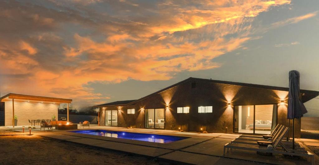 a house with a swimming pool in front of it at Luxury Desert Retreat w Pool & Jacuzzi in Joshua Tree