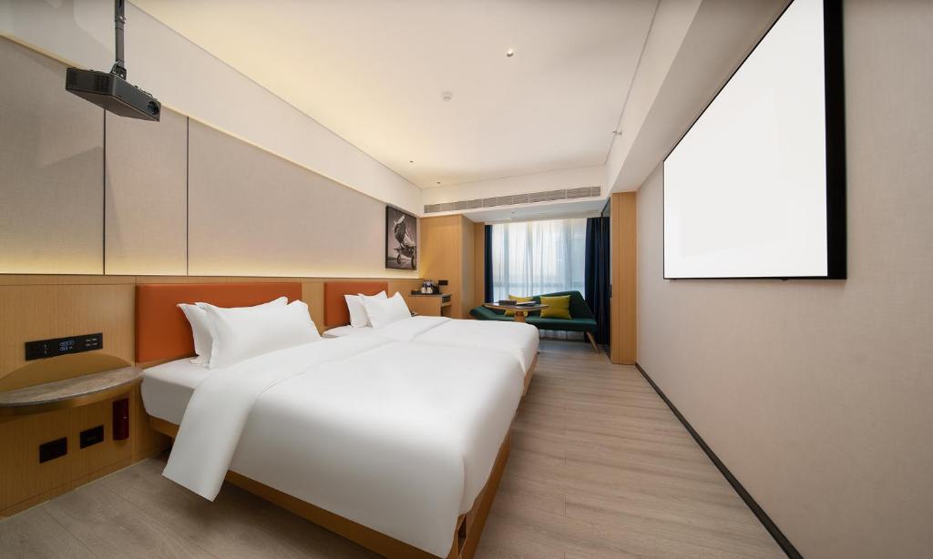 Postel nebo postele na pokoji v ubytování Guangzhou Baiyun Airport COCO Hotel