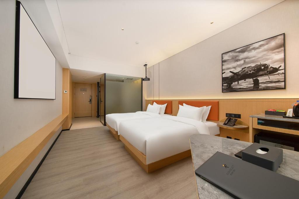 Postel nebo postele na pokoji v ubytování Guangzhou Baiyun Airport COCO Hotel