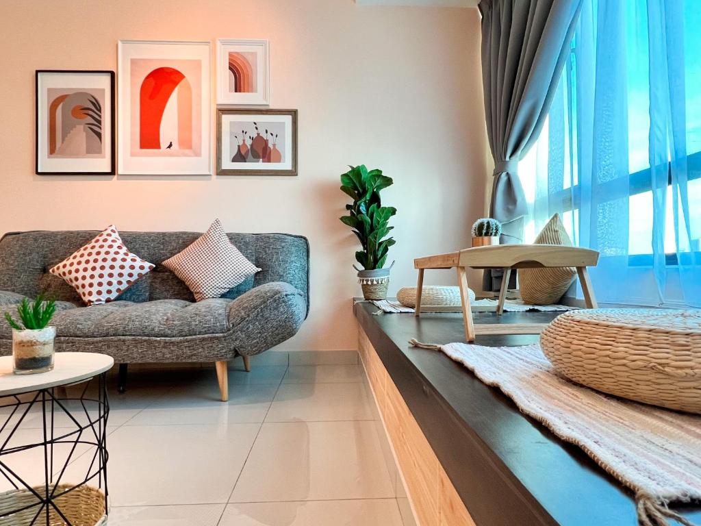 a living room with a couch and a table at Greenfield Residence Bandar Sunway in Petaling Jaya