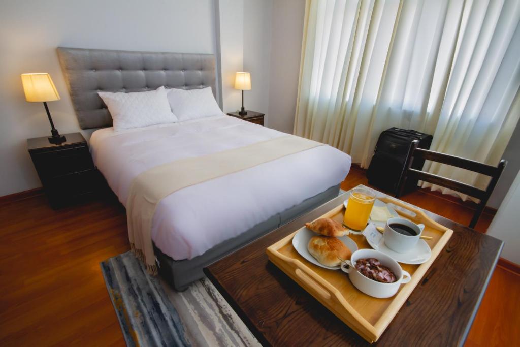 a hotel room with a bed and a tray of food at Casa Hotel Lago Titicaca in Puno