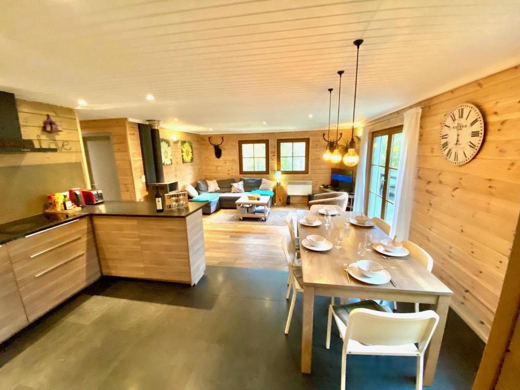 d'une cuisine et d'un salon avec une table et une horloge. dans l'établissement Chalet "A l Orée du bois", à Bullange