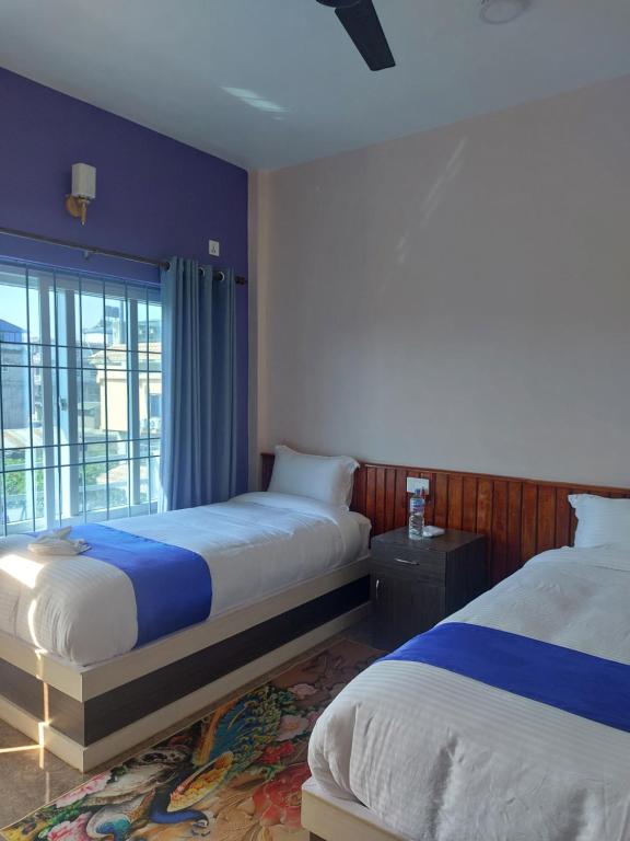 Hotel Namo Buddha في سوراها: غرفة فندقية بسريرين ونافذة