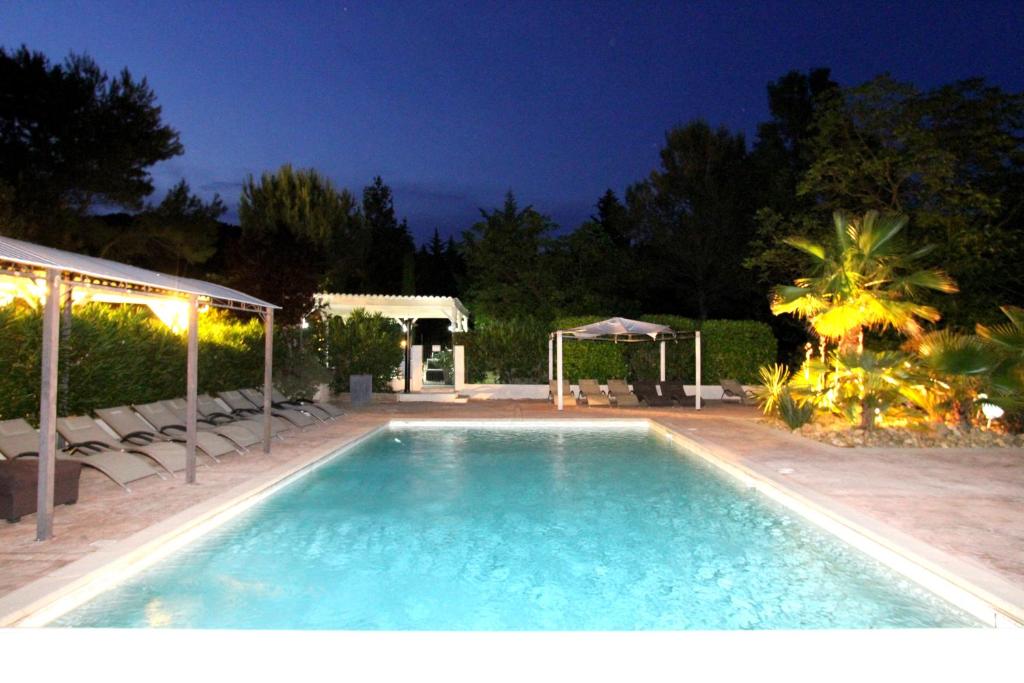 a swimming pool in a backyard at night at Auberge Des Pins in Tourrettes