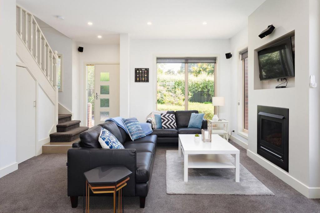 a living room with a couch and a fireplace at Boutique Stays - Mentone Abode in Mentone
