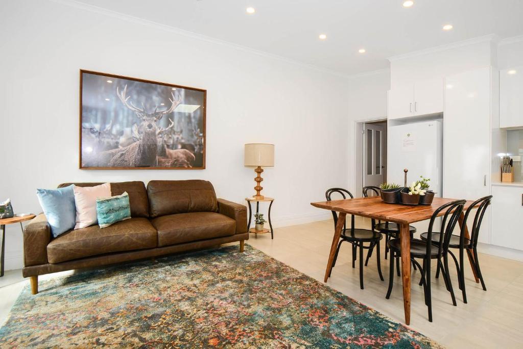 a living room with a couch and a table at Boutique Stays - Carlton Terrace in Melbourne