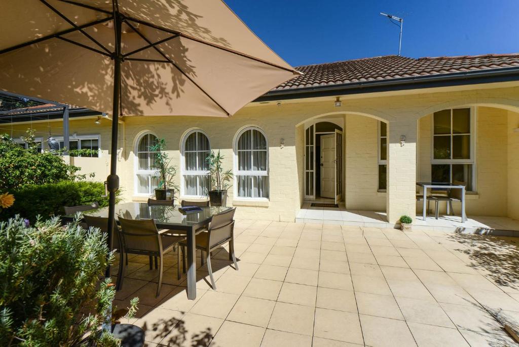 a patio with a table and an umbrella at Brighton Rose in Melbourne