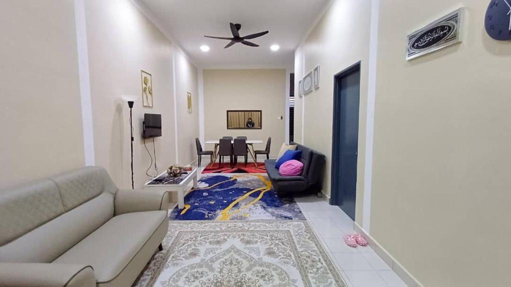 ein Wohnzimmer mit einem Sofa und einem Tisch in der Unterkunft HOMESTAY HONEY PARIT BUNTAR in Parit Buntar