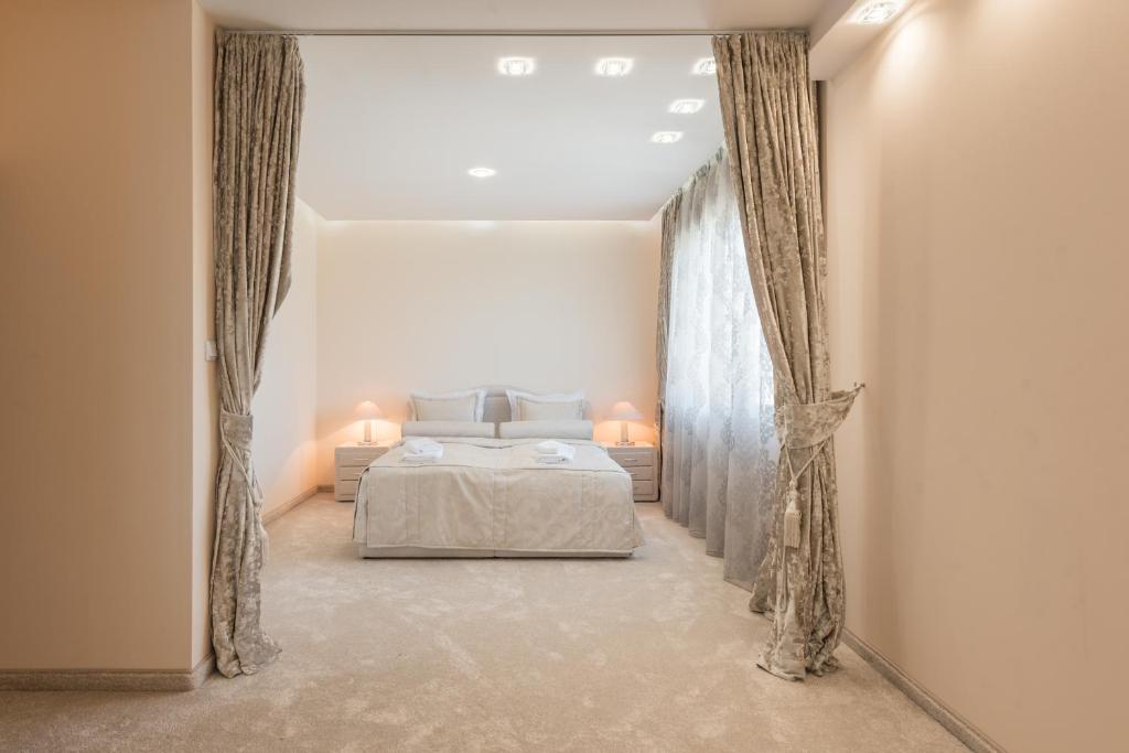 a bedroom with a bed and curtains in a room at Private Apartment in Chayka near the Sea Garden in Varna City