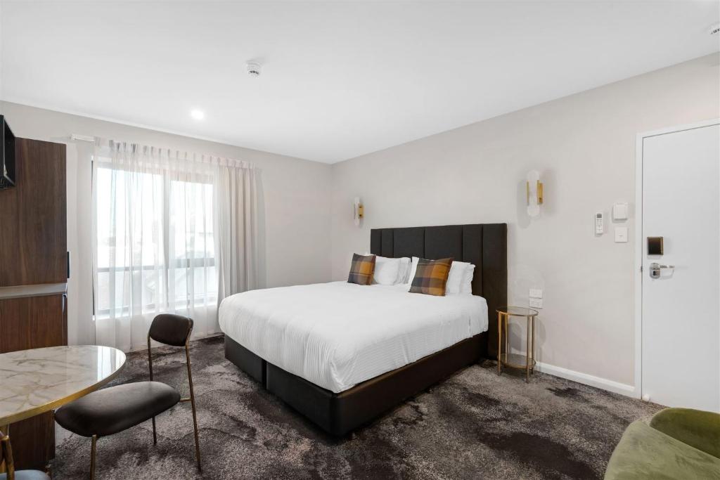 1 dormitorio con 1 cama, mesa y sillas en St Hugh Hotel Wagga Wagga, en Wagga Wagga