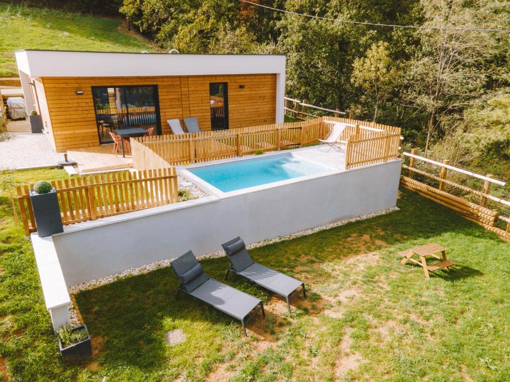 un patio trasero con piscina y una casa en -LA BOOA- Maison écologique 65m2 -Piscine privée- Ardèche GESTLOC, en Ozon