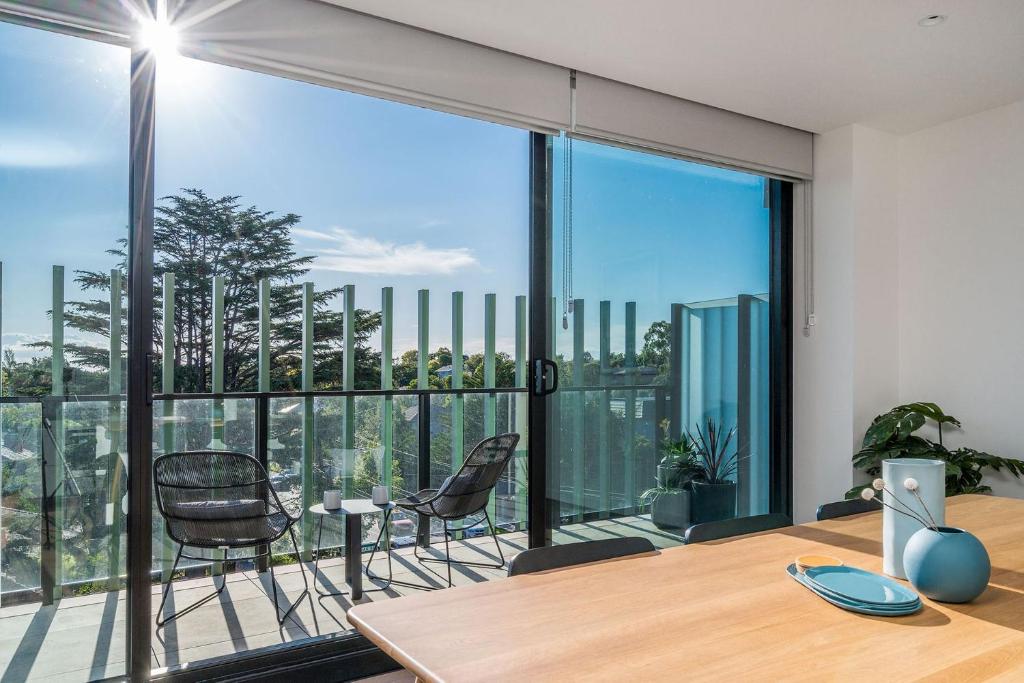una oficina con mesa, sillas y una ventana grande en Boutique Stays - Axel Apartments 203 The Bonfield en Melbourne