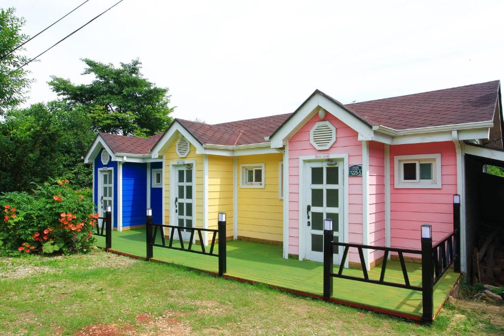 una fila de casas coloridas en un patio en Yangyang Pulbit Pension en Yangyang