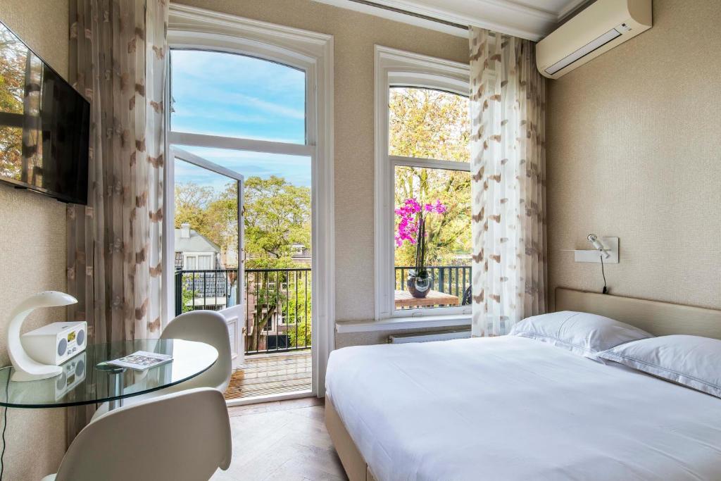 Postel nebo postele na pokoji v ubytování Amstel Corner Hotel