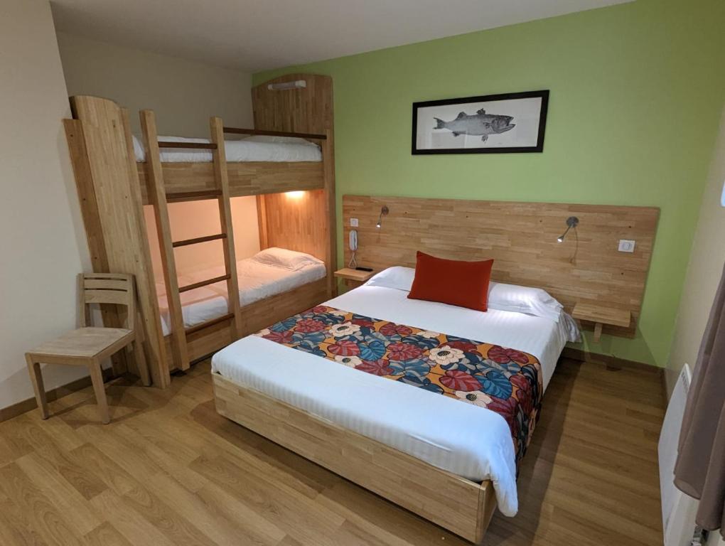 a bedroom with a bed and bunk beds in it at Le Libenter in Landéda