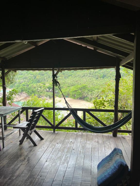 a porch with a hammock and a bench on a deck at Silver cliff in Than Sadet Beach