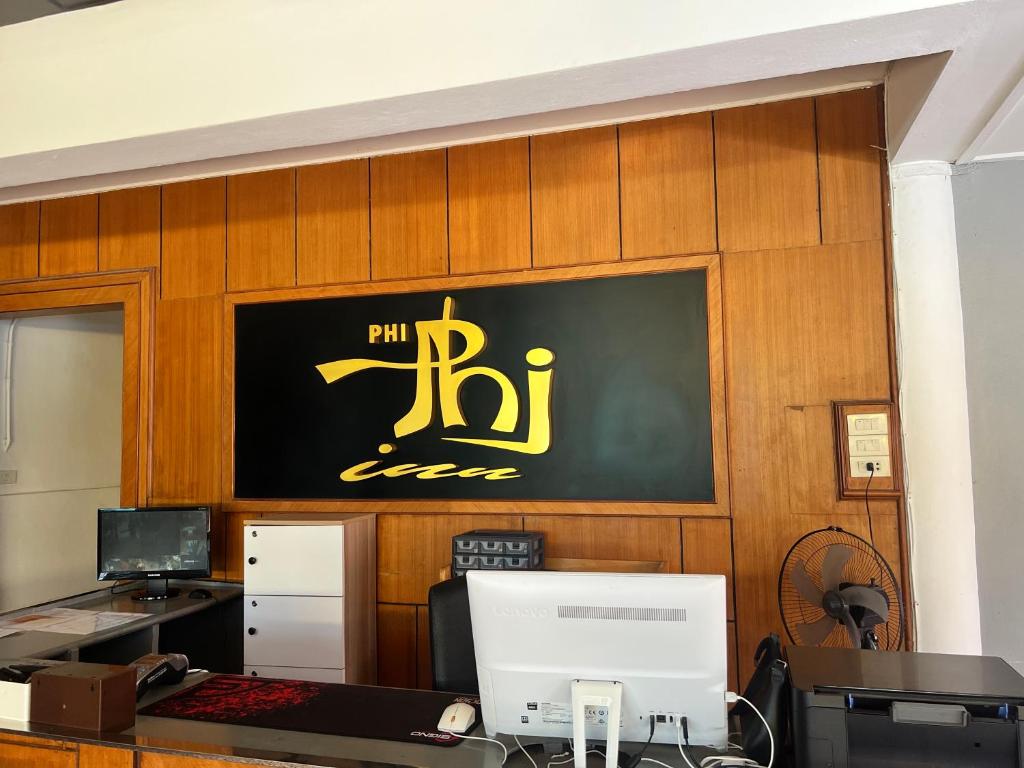 an office with a black and yellow sign on the wall at Phi Phi Inn in Phi Phi Islands