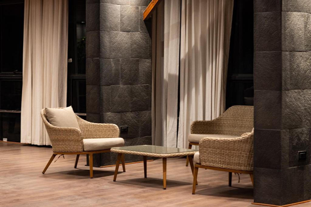 2 sillas y una mesa frente a una ventana en Hotel California Urubamba, en Urubamba