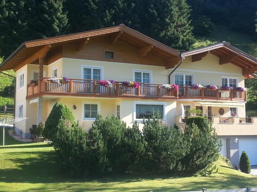 a large house with a balcony with flowers on it at Appartement Mühlbacher in Wagrain