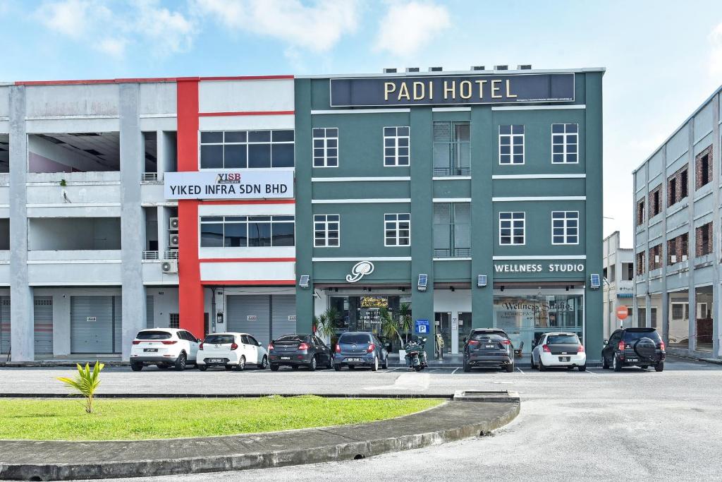 a parking lot with cars parked in front of a building at Capital O 90882 Padi Hotel in Alor Setar