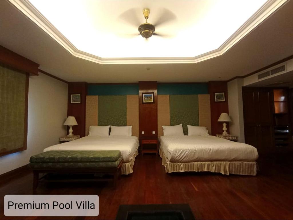 a hotel room with two beds and a ceiling at ALPINE GLX PD Port Dickson in Port Dickson