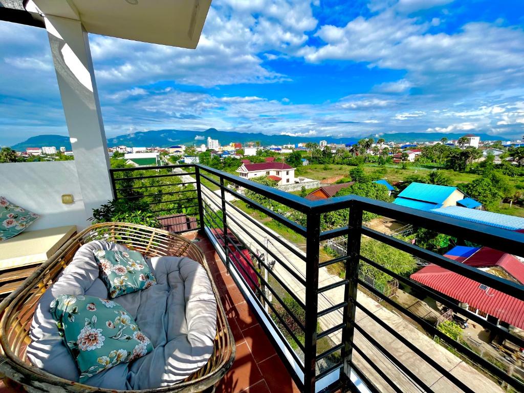 a balcony with a bed and a view of a city at Cambodhi - Vegan Guesthouse in Kampot