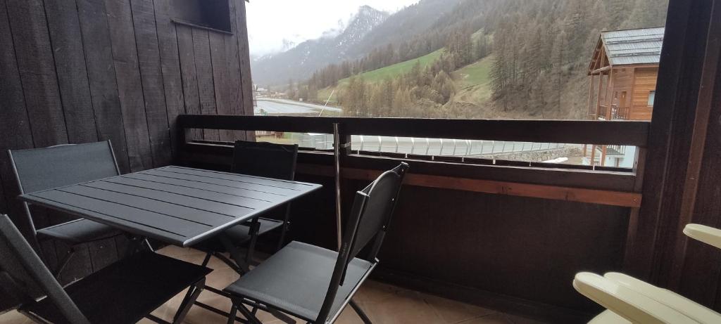 a table and chairs on a balcony with a view of a mountain at Appart 4-6 pers au pied des pistes toutes saisons in Molines-en-Queyras