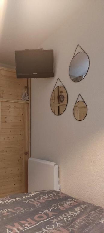 a room with a bed and mirrors on the wall at Appart 4-6 pers au pied des pistes toutes saisons in Molines-en-Queyras