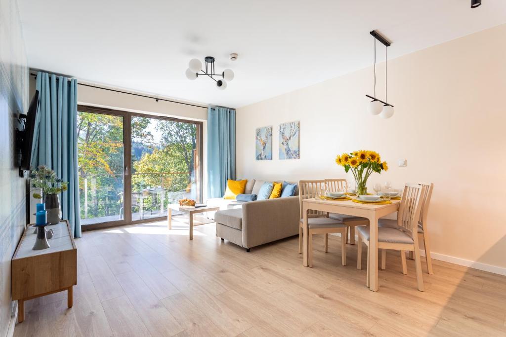 sala de estar con mesa y sofá en Stone Hill C38 Apart Invest- z dostępem do basenu, sauny, en Szklarska Poręba