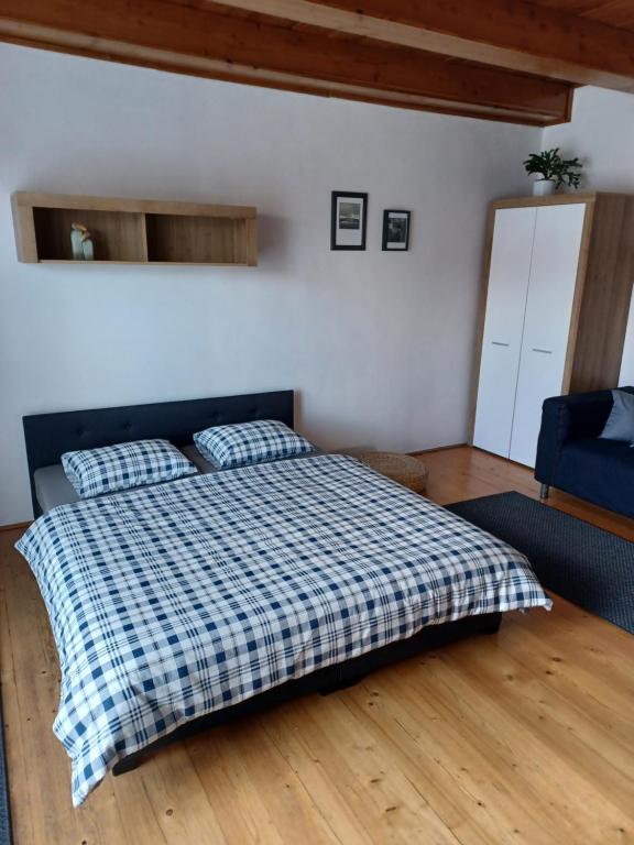 a bedroom with a bed with a checkered blanket at Apartmán Radenice 