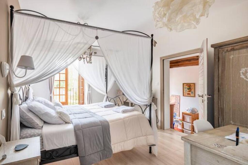 a bedroom with a white bed with a canopy at B&B Des Histoires d'Anges - Côté Jardin in Tournus