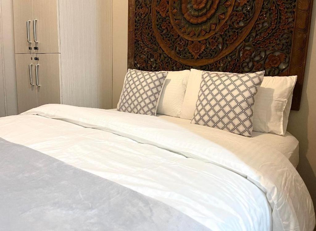 a bed with white sheets and pillows in a room at E-COMMERCE - EASTWOOD in Manila