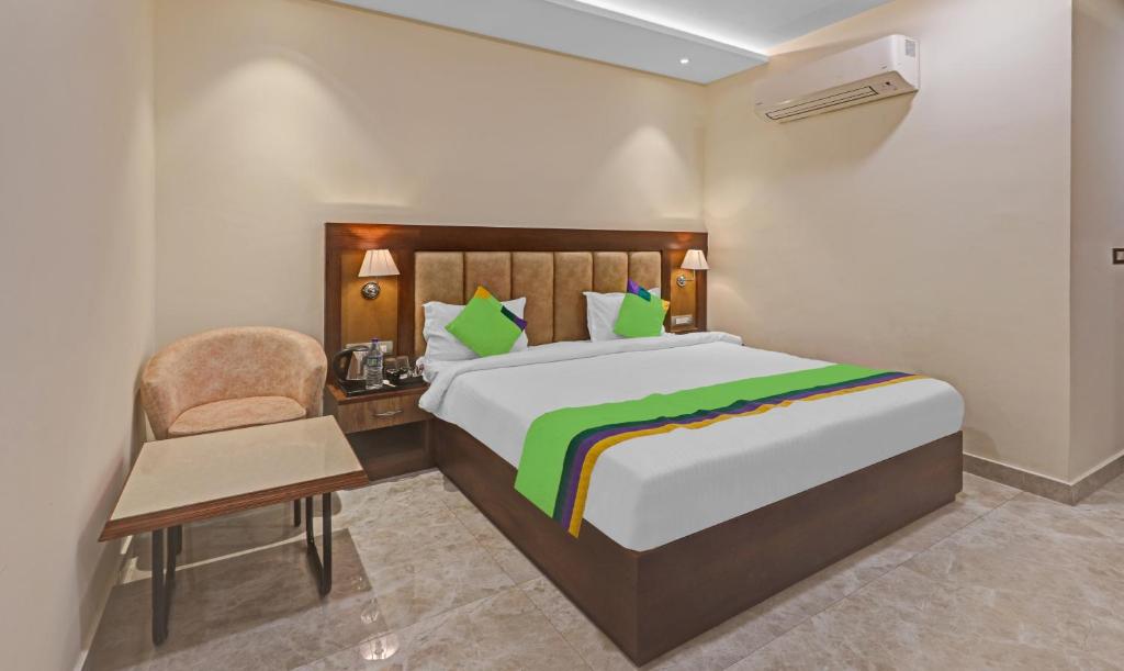 a bedroom with a bed and a desk and a chair at Treebo Trend Heaven Grand in Lucknow