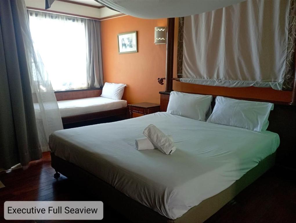 a hotel room with a large bed and a window at Alpine LXPD Full Seaview Water Chalet in Port Dickson