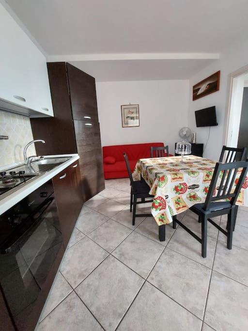 una cocina con mesa y una cocina con mesa y sillas en Casa Vacanze Lanuvio Stazione, en Lanuvio