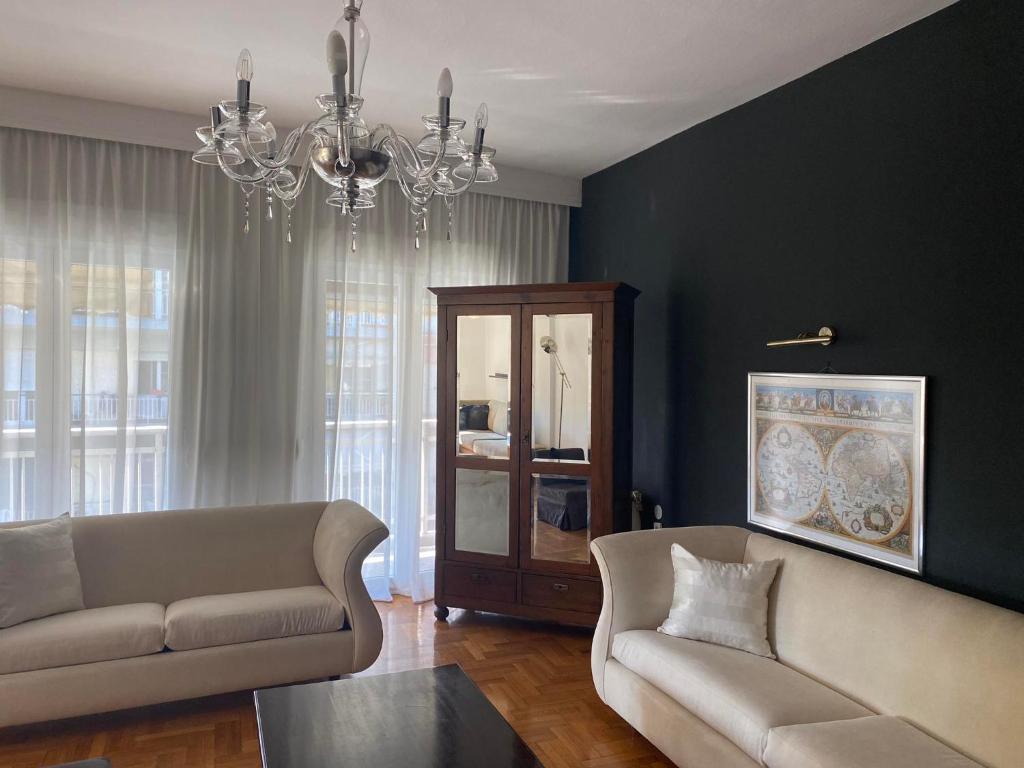 un soggiorno con divano e lampadario pendente di SERAFINA HOME a Salonicco