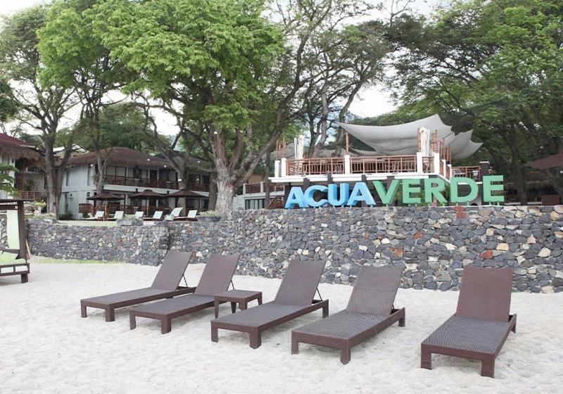 a group of lounge chairs sitting in the sand at Acuaverde Beach Resort in San Juan