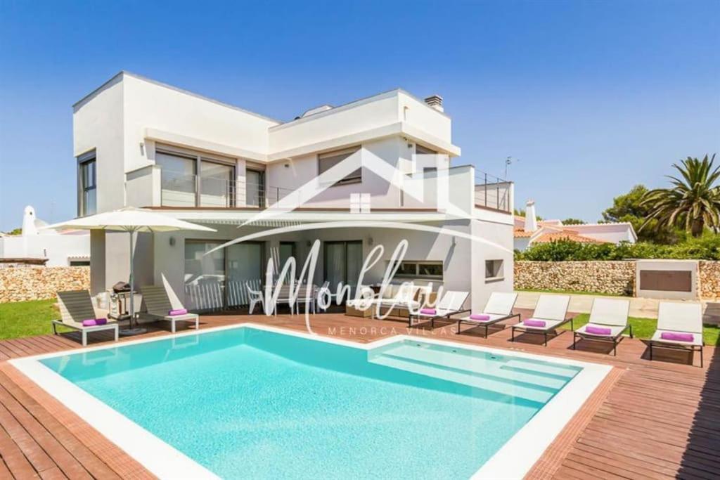 a villa with a swimming pool in front of a house at Villa Colom in Son Carrio