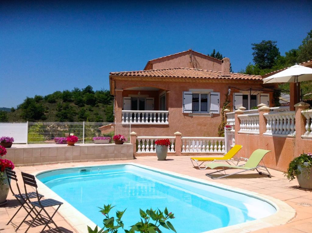 a swimming pool in front of a house at Chambres d'hôtes Les Noisetiers in Digne-les-Bains