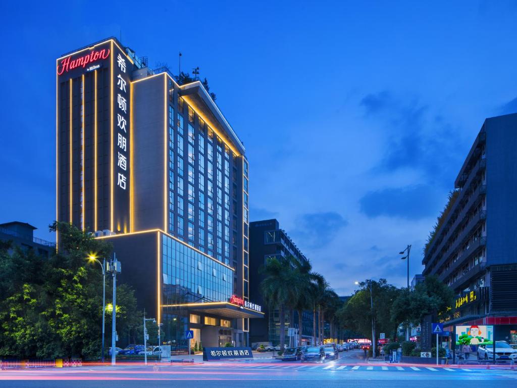 un edificio iluminado en una calle de la ciudad por la noche en Hampton by Hilton Shenzhen Bao'an Airport, en Shenzhen