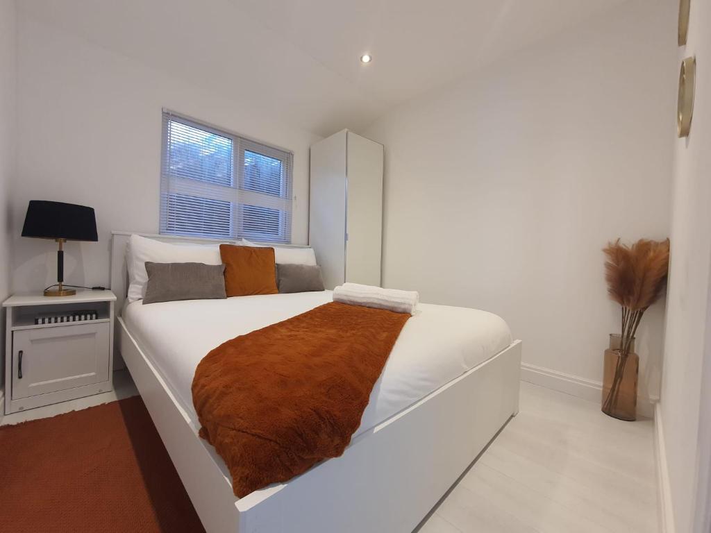 Un dormitorio con una cama blanca con una manta marrón. en Deluxe Pad with Sauna, en Low Street