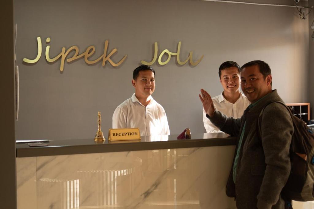 a group of men standing behind a counter at Hotel Jipek Joli in Nukus