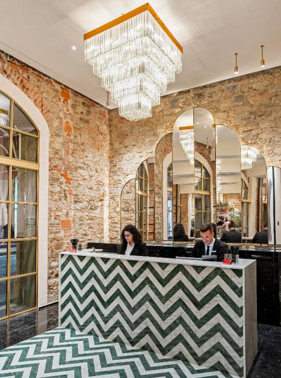 フィレンツェにあるHotel Calimala Florenceのロビーのカウンターに座る2名
