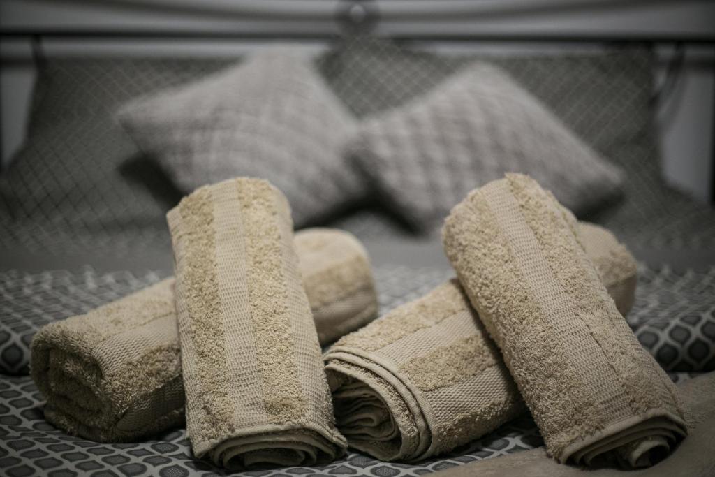 a group of four towels sitting on a bed at Central apartment's in Trikala in Tríkala