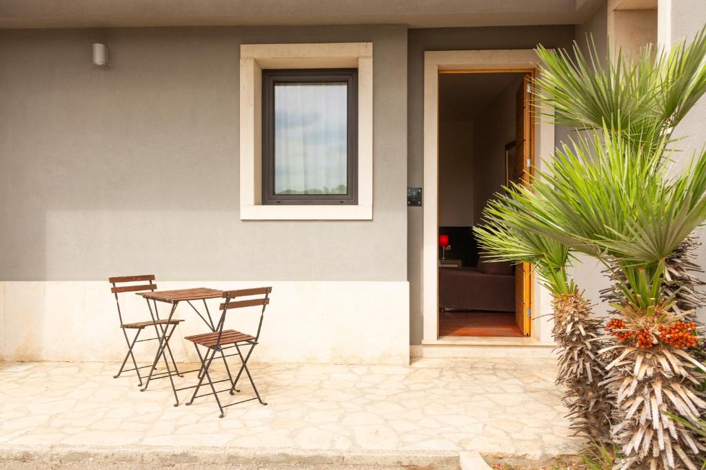 une terrasse avec une table et des chaises devant une maison dans l'établissement Hotel Ghalà, à Galatone