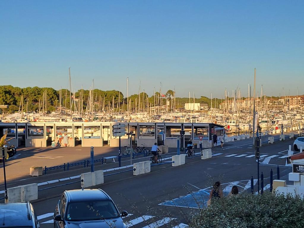 ein Parkplatz mit Autos und ein Yachthafen mit Booten in der Unterkunft Résidence l'ACCALMIE- Appartement pour 4 personnes proche du port de pêche in Capbreton