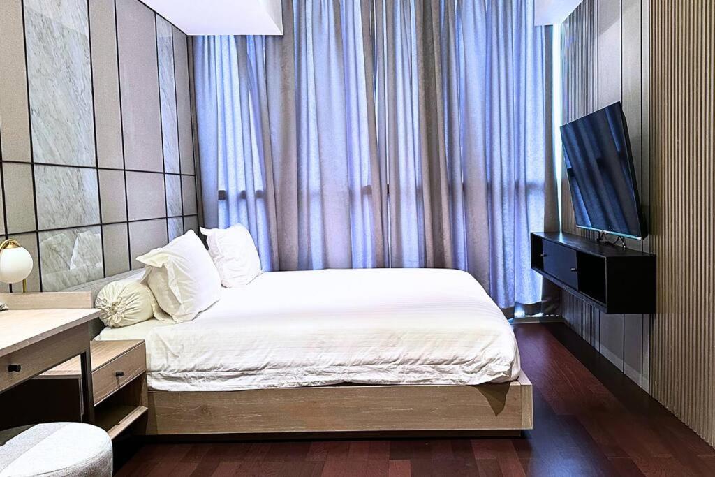 a bedroom with a bed and a flat screen tv at Lux & Spacious 3BR in Central Jakarta in Jakarta